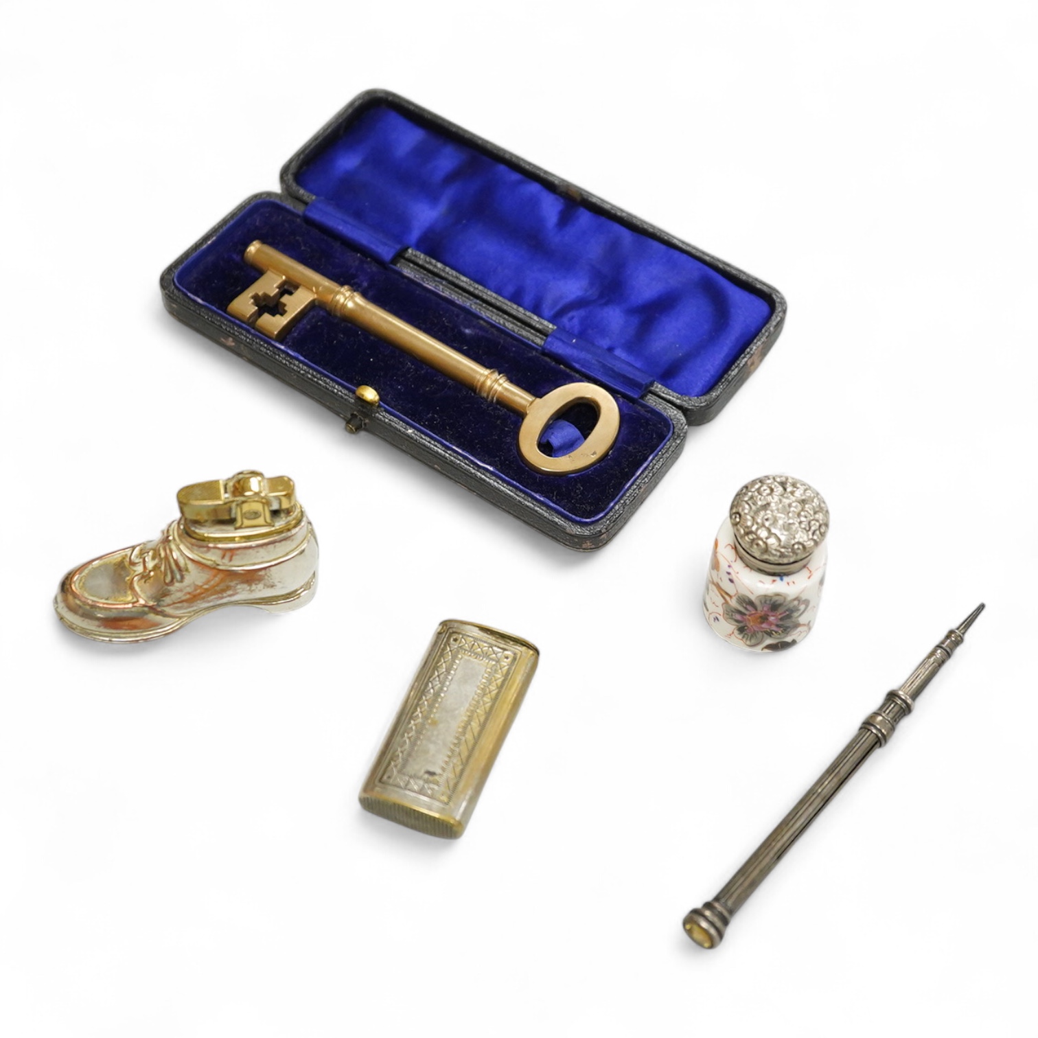 A collection of sundry items to include a large cased key, novelty lighter in the form of a shoe and a citrine set propelling pencil
